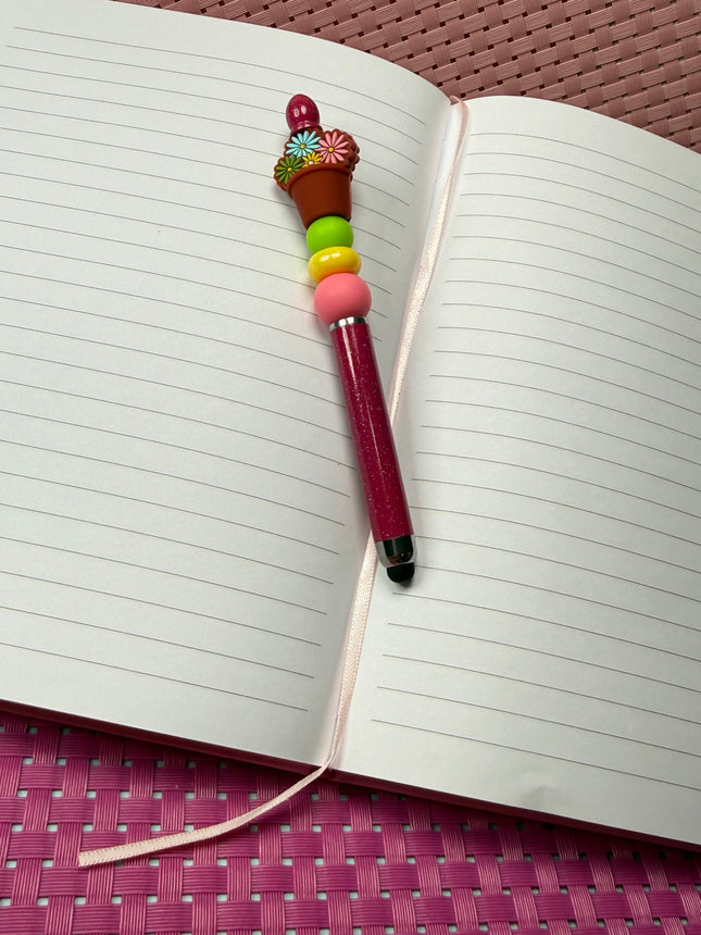 Stylus pen deep Maroon with shimmer featuring pink, yellow and green silicone beads with a focal of potted daisy flowers in multiple colors. 