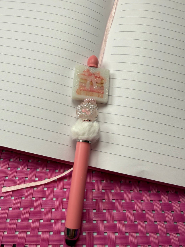 Pink Stylus pen with white fluffy spacer with pearl; rhinestone bead and pink spacer with a glittery white focal of stacked books with pink coquette bow. 
