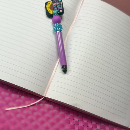 Purple Shimmer Stylus Pen With focal that says, She believed she could So She did with half sunflower. Features Purple silicone bead & rhinestone turquoise bead. 