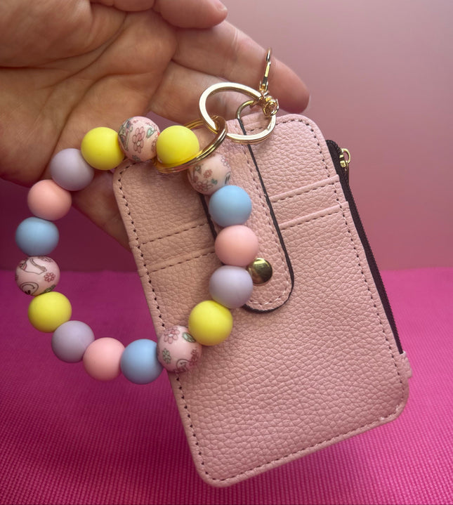 Pastel Smiley Wristlet Wallet Combo featuring a blush faux leather wallet with ID holder, zipper coin pouch, and pastel silicone beaded wristlet with retro smiley flower beads.
