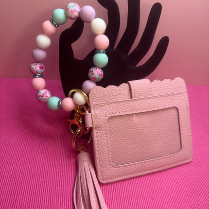 Pastel Floral Wristlet Wallet Combo featuring a blush pink faux leather wallet with clear ID holder, floral silicone beaded wristlet, teal rhinestone spacers, gold hardware, and matching tassel.