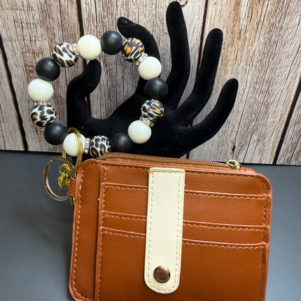 Handmade cognac faux leather wallet with matching black, ivory, and leopard print silicone beaded wristlet featuring multiple card slots, clear ID window, rhinestone spacers, and gold hardware.