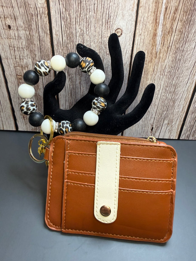Handmade cognac faux leather wallet with matching black, ivory, and leopard print silicone beaded wristlet featuring multiple card slots, clear ID window, rhinestone spacers, and gold hardware.