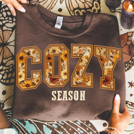Brown Cozy Season sweatshirt with oversized COZY lettering filled with yellow, cream, rust and brown autumn floral print.
