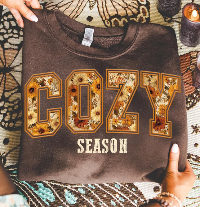 Brown Cozy Season sweatshirt with oversized COZY lettering filled with yellow, cream, rust and brown autumn floral print.