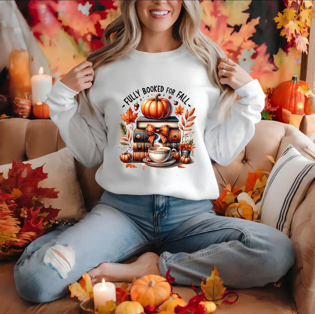 White Fully Booked for Fall sweatshirt featuring stacked books, pumpkin, steaming coffee and autumn leaves.