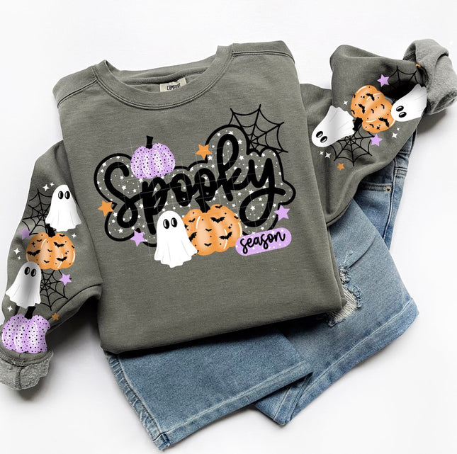 A folded heather gray sweatshirt with a 'Spooky Season' Halloween graphic, styled on top of light-wash blue jeans against a white background.
