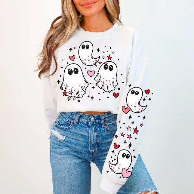 Person wearing a white sweatshirt with cartoon ghost designs on a plain background