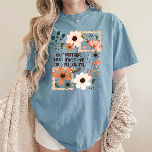 Blue t-shirt with floral design and motivational quote worn by a person.