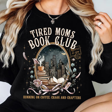 Person wearing a black sweatshirt with 'Tired Moms Book Club' design.