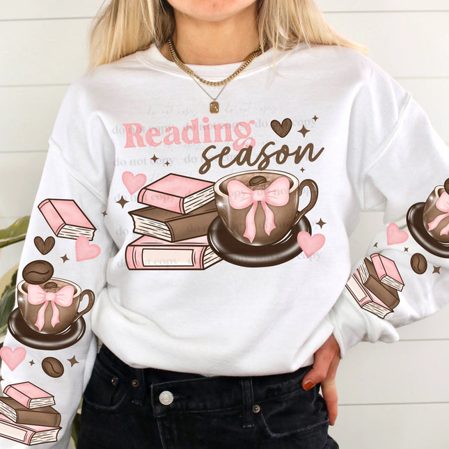 White sweatshirt with 'Reading Season' design featuring coffee cups and books.