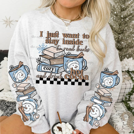 Person wearing a white sweatshirt with a graphic design featuring books, hot cocoa, and text.