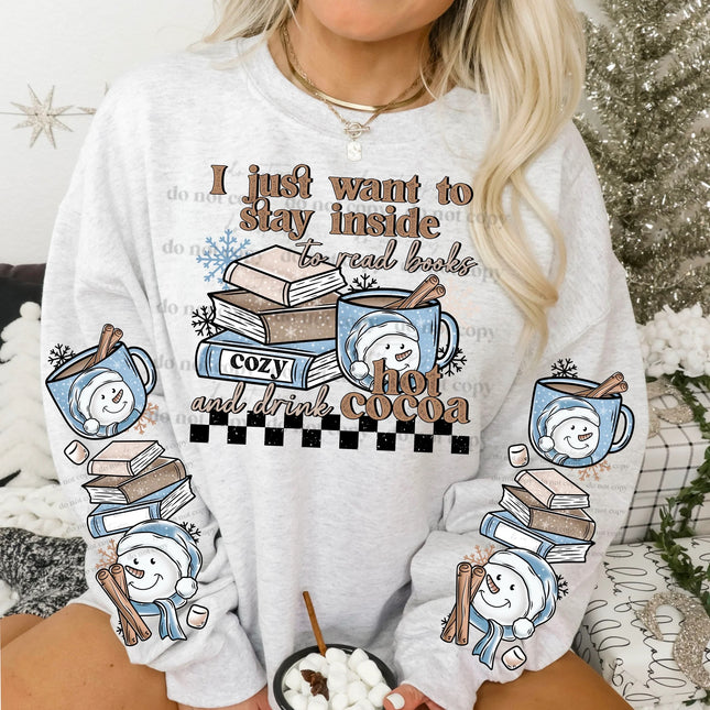 Person wearing a white sweatshirt with a graphic design featuring books, hot cocoa, and text.
